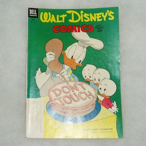 May include: Vintage Dell Comic magazine featuring Walt Disney's Comics and Stories. The cover shows Donald Duck decorating a cake with the words "DON'T TOUCH" while his nephews watch. The magazine has a green background and the price is 10¢.