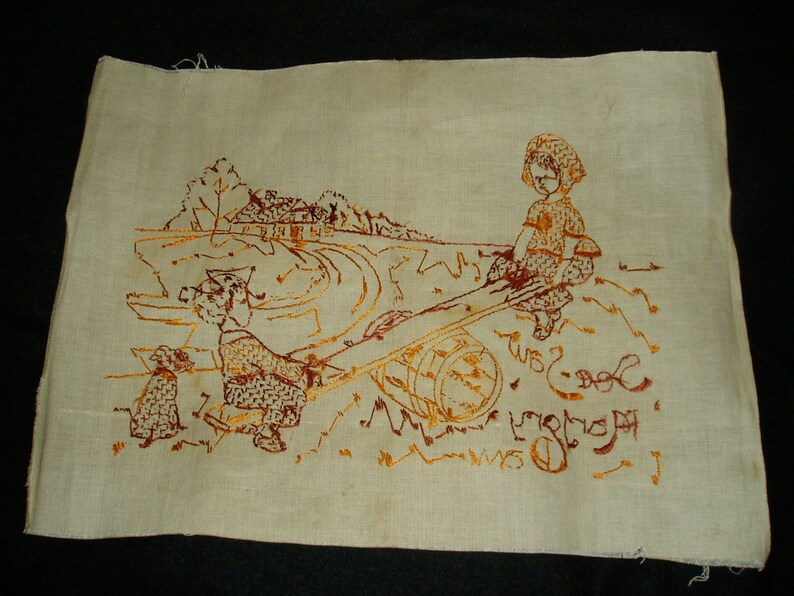 May include: A rectangular piece of off-white fabric featuring a brown embroidered scene of two children playing on a seesaw with a dog nearby. The embroidery includes a landscape with a house and trees in the background, along with the text See-Saw.