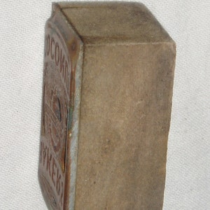 May include: A vintage, rectangular, brown matchbox with a worn, faded label that reads "ОСОБЫЙ ВКУС".