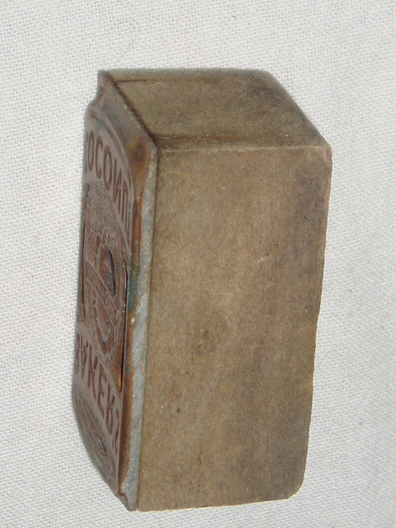 May include: A vintage, rectangular, brown matchbox with a worn, faded label that reads "ОСОБЫЙ ВКУС".