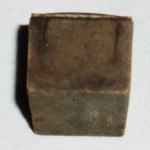 May include: A small, square, brown, wooden box with a slightly worn surface.
