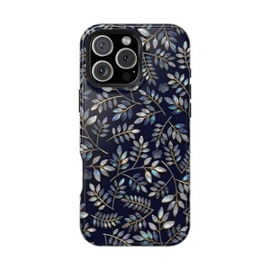 Op de afbeelding: Een marineblauwe telefoonhoes met een botanisch ontwerp. De hoes heeft een patroon van gestileerde bladeren en kleine bloemen in tinten blauw, zilver en goud. De hoes heeft een glanzende afwerking en een cameramodule met drie lenzen.