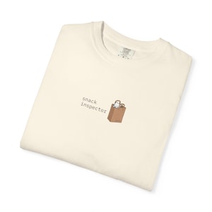紙袋に入ったスナック検査官猫のTシャツ