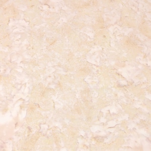 May include: A close-up of a light beige textured surface with a subtle marbled pattern. The surface has a smooth, slightly grainy texture.