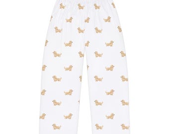 May include: White pajama pants with a repeating pattern of tan dachshund dogs. The pants have a wide leg and a comfortable, relaxed fit. The dachshunds are in a walking pose.