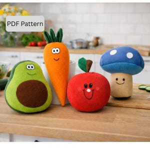 May include: A collection of plush food toys, including an avocado, carrot, apple, and mushroom. The toys are made of felt and feature smiling faces. The carrot is orange, the avocado is green and brown, the apple is red, and the mushroom is blue and beige. The text "PDF Pattern" is in the image.