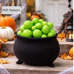 May include: A black cauldron filled with green spheres, possibly decorative. The cauldron has three small feet and is set against a backdrop of pumpkins and autumn leaves. The text "PDF Pattern" is in the upper left corner.