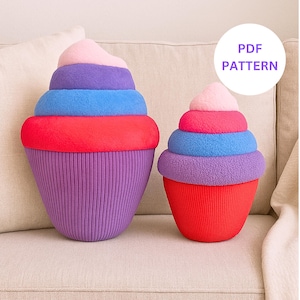 May include: Two cupcake-shaped pillows in vibrant colors. The larger pillow has a purple base, red middle, blue layer, purple layer, and pink top. The smaller pillow has a red base, purple layer, blue layer, pink middle, and pink top. The image includes the text "PDF PATTERN".