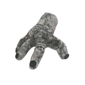 May include: A plush, gray hand with black fingertips and stitched details. The hand is a novelty item, likely a prop or decorative piece, with a textured appearance and a slightly eerie aesthetic.