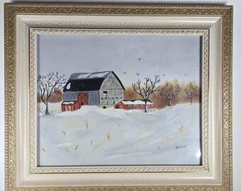 May include: Framed painting of a winter landscape featuring a gray barn with a black roof and a red building. The scene is set in a snowy field with leafless trees under a gray sky. The frame is gold.
