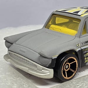 Könnte beinhalten: Ein Set aus drei Keramikbechern mit gesprenkelter, matter Oberfläche. Die Becher sind in Creme-, Hellgrau- und Dunkelgrautönen gehalten. Jede Tasse hat ein schlichtes, minimalistisches Design.