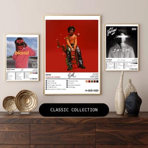 Puede incluir: Una colección de carteles enmarcados de arte de álbumes de música. Los carteles presentan portadas de álbumes con texto y gráficos. El cartel central muestra una imagen de una persona con el texto "D4VD PETALS TO THORNS". La parte inferior de la imagen tiene el texto "CLASSIC COLLECTION".