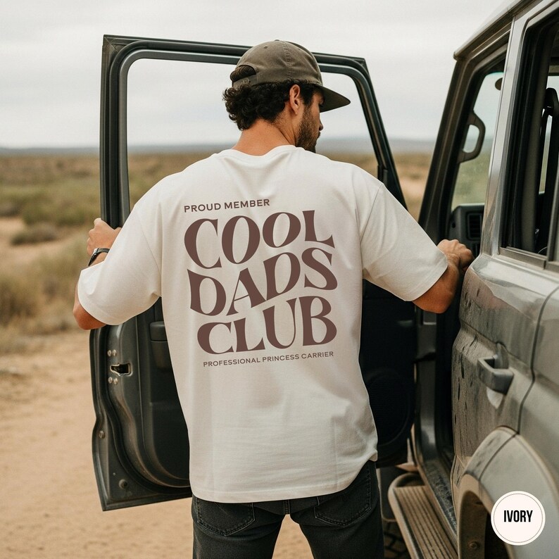 Back view of an ivory Comfort Colors shirt featuring a large taupe Cool Dads Club graphic and Professional Princess Carrier wording.