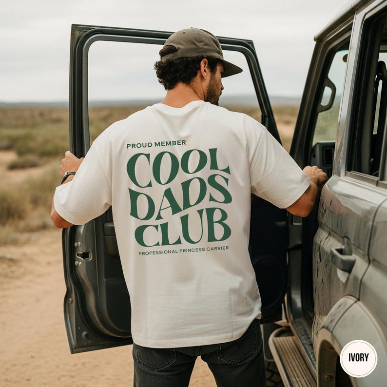 Back view of an ivory Comfort Colors shirt featuring a large green Cool Dads Club graphic and Professional Princess Carrier wording.