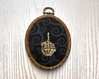 Gold Skeleton middle finger oval wall art, Hand Embroidered, Metallic gold, black and gray swirls, wood look hoop frame