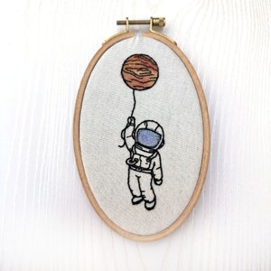 Little Astronaut hanging on to a planet Finished water color hand embroidery wall art small size image 1