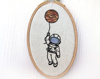 Little Astronaut hanging on to a planet Finished water color hand embroidery wall art small size