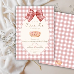 Può includere: Un invito a motivo gingham rosa e bianco con un fiocco rosso e il testo "A Little Cutie Pie is Turning One". L'invito include i dettagli per il primo compleanno di Annabelle.