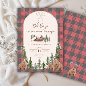 May include: A baby shower invitation with a rustic design. The invitation features a red and grey plaid pattern and includes the text "Oh Boy! Let the adventure begin." The design incorporates illustrations of bears, trees, and mountains. The date and time of the event are also displayed.