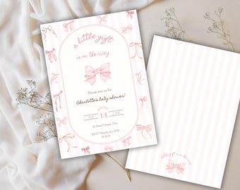 Puede incluir: Una invitación a un baby shower con un diseño de lazo rosa. La invitación presenta el texto "a little gift is on the way" y los detalles del baby shower de Charlotte, incluyendo la fecha, hora e información de RSVP. El fondo es blanco con rayas rosas.