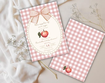 May include: Two baby shower invitations with a pink gingham pattern. One invitation features an oval frame with text and a watercolor apple. The text reads "the apple of our eye is on the way" and "Charlotte's baby shower!"