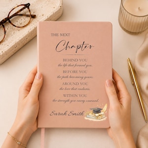 Op de afbeelding: Een oudroze notitieboek met de tekst THE NEXT Chapter, gevolgd door een gedicht over het leven, de naam Sarah Smith en een kleine illustratie van een afstudeerhoed op een stapel boeken, alles in zwarte inkt op de kaft gedrukt.