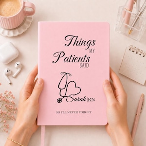 Pode incluir: Um caderno rosa claro com texto preto que diz Things MY Patients SAID, um estetoscópio em forma de coração, o nome Sarah RN e o texto SO I'LL NEVER FORGET. O caderno tem uma capa lisa e uma fita marcadora rosa na vertical.
