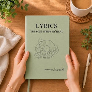 Peut inclure: Un carnet vert sauge avec le texte LYRICS THE SONG INSIDE MY HEAD imprimé en noir. Sous le texte se trouve une illustration au trait d'un disque vinyle, d'une clé de sol et de notes de musique. Le coin inférieur droit porte le texte Written by: Sarah.