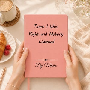 May include: A coral pink hardback journal featuring the black text "Times I Was Right and Nobody Listened" printed on the front cover, accompanied by a decorative horizontal line and the text "By Maria" in a cursive script font.