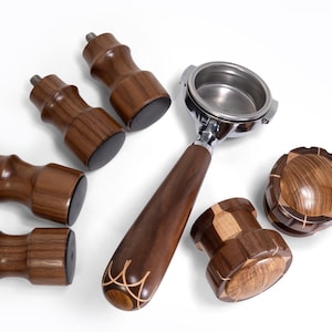 May include: An assortment of espresso machine accessories, including a portafilter with a wooden handle, wooden feet, and a wooden tamper. The items are made of dark brown wood with a polished finish. The word "Vintage" is in the bottom right corner.