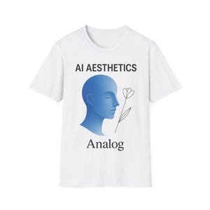 以下が含まれることがあります： 「AI Aesthetics」の文字と、青いグラデーションの頭のシルエット、花の線画が描かれた白いTシャツ。「Analog」の文字が頭の下に黒で配置されています。デザインはTシャツの中央に配置されています。