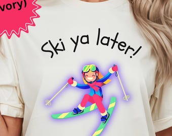 Könnte beinhalten: Elfenbeinfarbenes T-Shirt mit dem Text "Ski ya later!" über einem Cartoon-Skifahrer in bunter Skiausrüstung. Der Skifahrer trägt ein blaues, rotes und pinkfarbenes Outfit mit grünen Skiern und Stöcken. Eine rosa Sternform mit dem Wort "(Ivory)" befindet sich oben links.