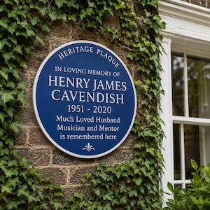 Puede incluir: Una placa conmemorativa circular azul con texto blanco que dice HERITAGE PLAQUE, IN LOVING MEMORY OF HENRY JAMES CAVENDISH, 1951-2020, Much Loved Husband, Musician and Mentor is remembered here, con un pequeño adorno decorativo blanco en la parte inferior.