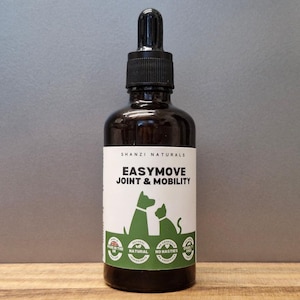 Op de afbeelding: Een donkerbruine glazen fles met een zwarte druppelaar. Het etiket leest "EASYMOVE JOINT & MOBILITY" met een silhouet van een hond en kat. Extra tekst omvat "SHANZI NATURALS", "Made in the UK", "Natural", "No nasties" en "Cruelty Free".