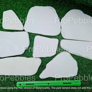 May include: A collection of smooth, white decorative stones of various shapes and sizes, arranged on a green surface. A green ruler is at the bottom. The text "ProPebbles" is watermarked across the image.