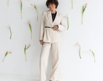Conjunto feminino de blazer e calça palazzo de pernas largas, com blazer e cinto na cintura.