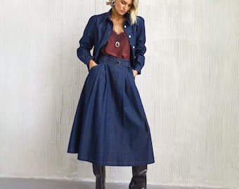 Conjunto jeans de duas peças: blazer ajustado com botões e saia jeans longa abaixo do joelho.