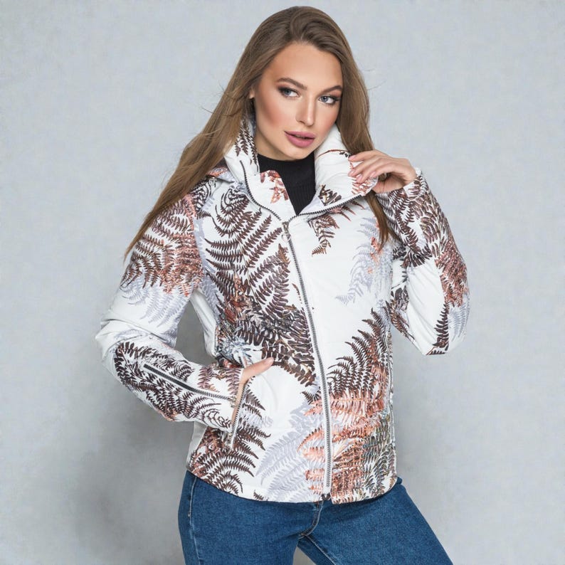 This white puffer jacket blends high-fashion botanical prints with functional design, keeping you comfortable in temperatures down to -5C.

Top Performance Specs
❄️ Insulation: Premium Biosilicone 120 mm for a light down jacket feel.
❄️ Weatherproof: Durable, waterproof raincoat fabric (100% polyester).
❄️ Closure: Unique voluminous diagonal zip puffer coat.
❄️ Collar: High stand-up style for wind protection.
❄️ Utility: Convenient slit pockets and decorative sleeve zippers.
