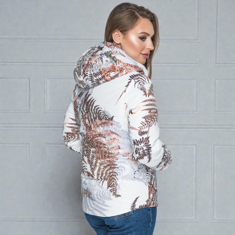 This white puffer jacket blends high-fashion botanical prints with functional design, keeping you comfortable in temperatures down to -5C.

Top Performance Specs
❄️ Insulation: Premium Biosilicone 120 mm for a light down jacket feel.
❄️ Weatherproof: Durable, waterproof raincoat fabric (100% polyester).
❄️ Closure: Unique voluminous diagonal zip puffer coat.
❄️ Collar: High stand-up style for wind protection.
❄️ Utility: Convenient slit pockets and decorative sleeve zippers.
