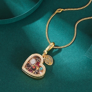 Puede incluir: Un collar con colgante en forma de corazón dorado con un centro transparente lleno de gemas y abalorios de colores. El colgante está delineado con pequeños cristales transparentes y cuelga de una delicada cadena dorada. Una pequeña etiqueta dorada dice "LIMITED EDITION 2011".