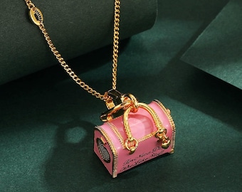 Juicy Couture pink enamel and gold-tone pet dog carrier charm.