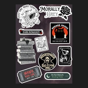 May include: A collection of spooky stickers with various designs. Includes a skeleton reading a book, a black cat with candles, and the text "HORROR BOOKS HAVE NO EFFECT ON ME." Other stickers feature text like "DARK ROMANCE" and "MASKED MEN DO IT FOR ME."