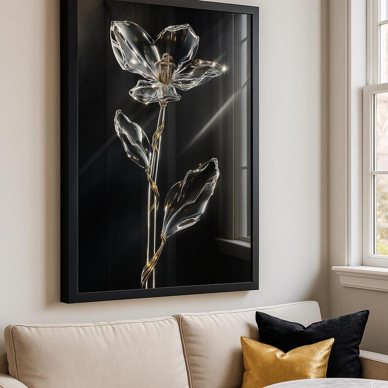 May include: Framed artwork of a clear glass flower with a gold stem and leaves against a black backdrop. The flower has detailed petals and a central structure. The artwork is displayed on a wall above a beige sofa in a living room.