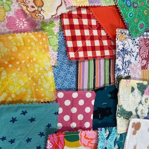 Puede incluir: Un mosaico de cuadrados de tela coloridos con diversos patrones. Los cuadrados incluyen estampados florales, cuadros vichy, lunares y patrones de estrellas. Las telas están acolchadas con hilo blanco, creando una superficie texturizada.