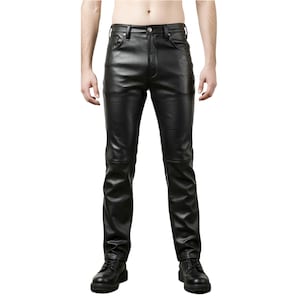 Op de afbeelding: Zwarte leren broek met een klassiek vijf-zakken ontwerp. De broek heeft een rechte pijp en een knoop- en ritssluiting. Het leer ziet er glad uit en heeft een lichte glans. De broek wordt gecombineerd met zwarte leren laarzen.