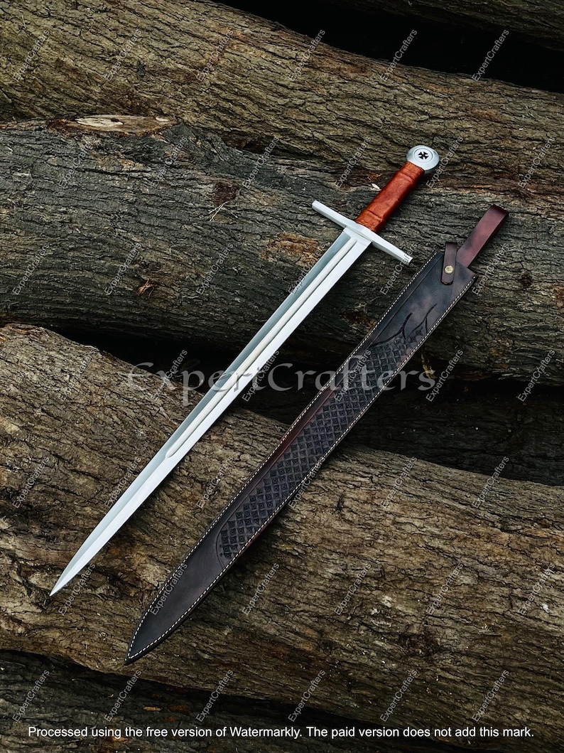 May include: A medieval-style sword with a polished steel blade and a brown leather-wrapped handle. The sword rests on a wooden surface next to a matching leather sheath with decorative stitching and embossed patterns.