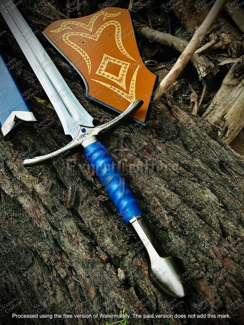 May include: A silver and blue sword with a decorative hilt and a blue handle. The sword is displayed with a brown shield with gold accents. The sword's blade is approximately 24 inches long.