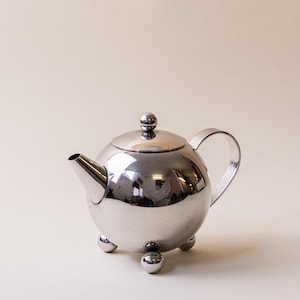 Kulisty czajnik w stylu postmodernistycznym na nóżkach w kształcie kuli | Chromowany czajnik w kształcie kuli
