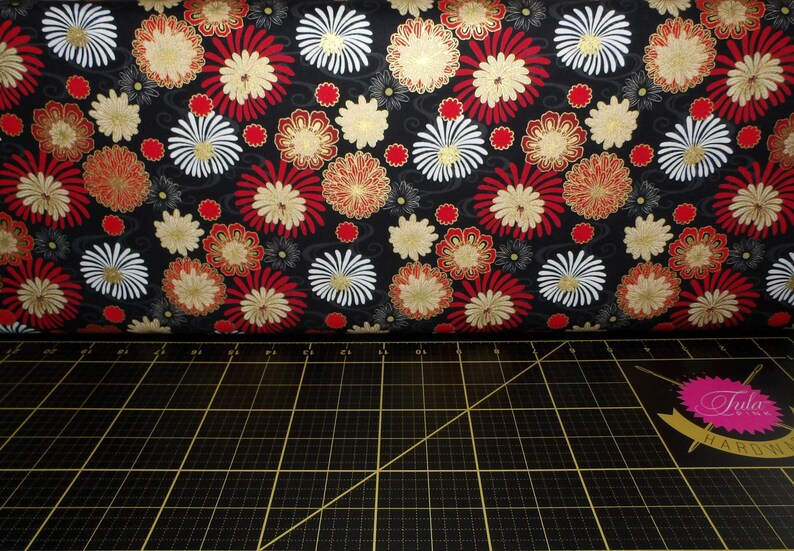 May include: Black fabric with a repeating pattern of red, white and gold flowers. The fabric has a subtle shimmer.