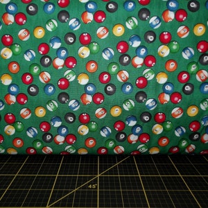 May include: Green fabric with a repeating pattern of colorful billiard balls. The balls are numbered 1 through 15.